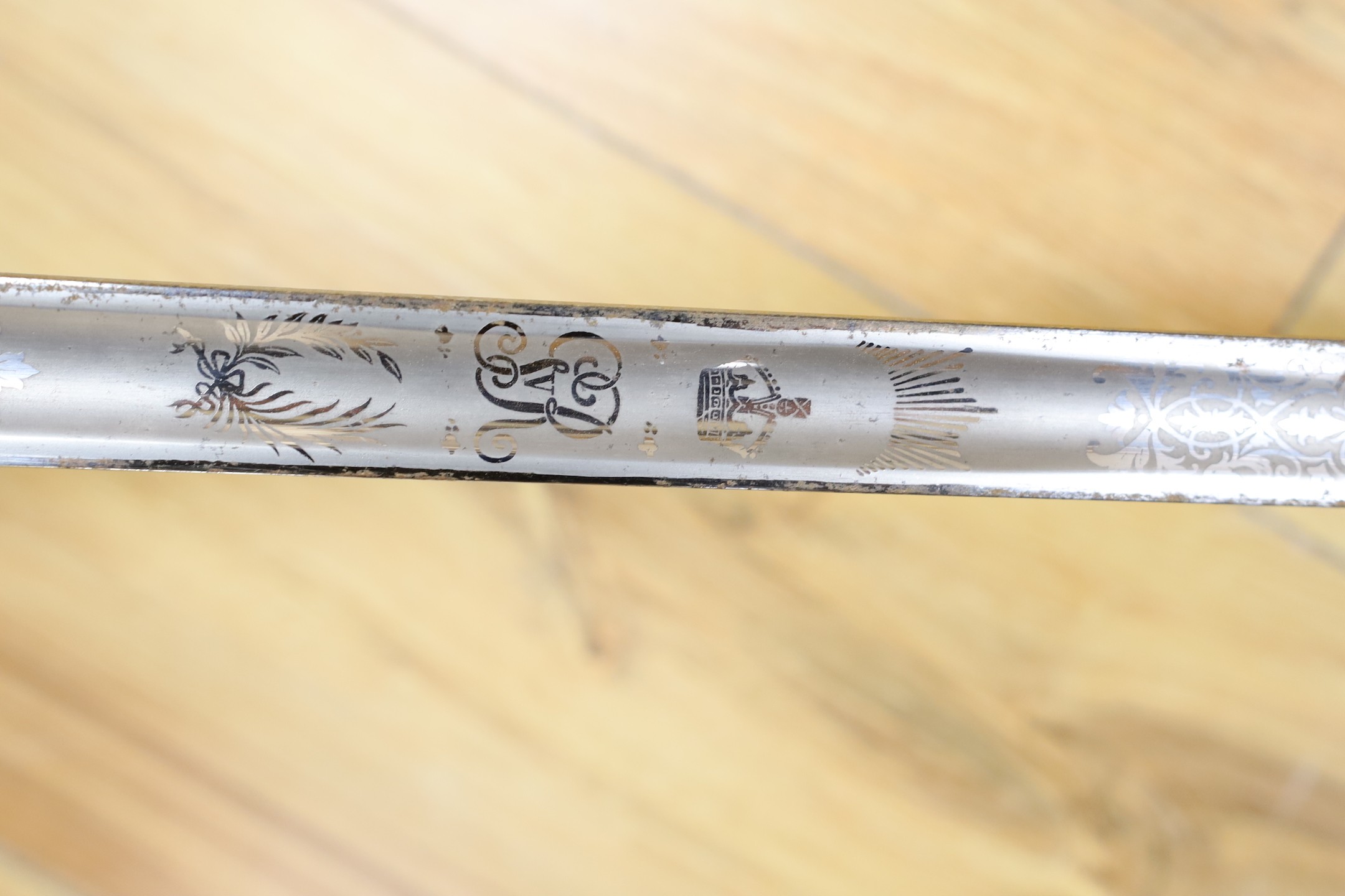 A George V military dress sword in brown leather covered scabbard, 102cm long, and a Middle Eastern dagger with carved and painted handle
